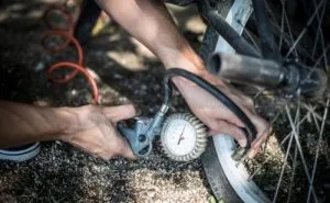 Portable electric inflator beside a bicycle wheel