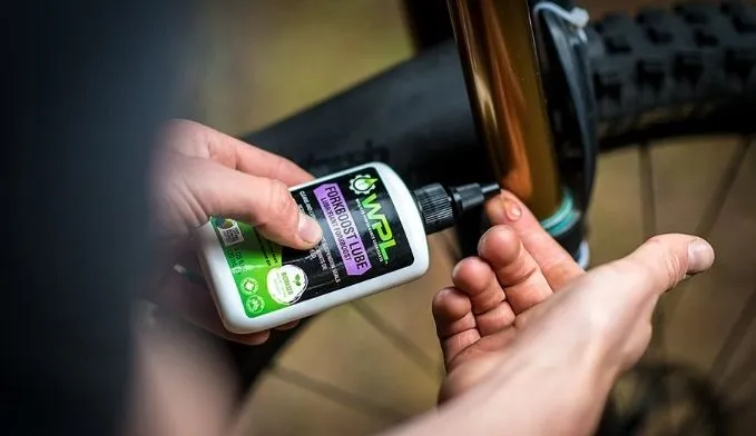 Bicycle chain lubricant beside a mountain-bike drivetrain