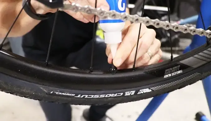 Measured tubeless sealant being added to a bicycle tire